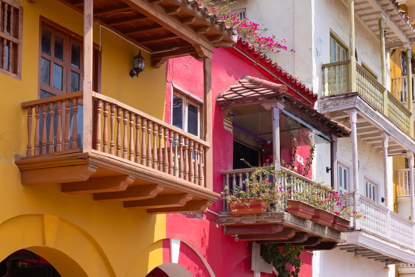 Balcones coloniales de madera y fachadas amarillas y rosadas en la ciudad amurallada de Cartagena de Indias